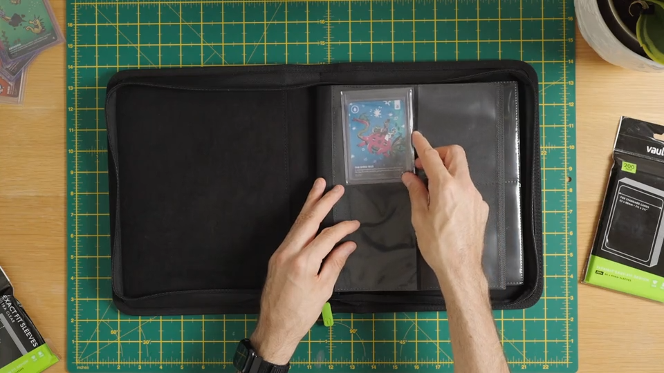 Charger la vidéo : A video showing a trading card being put into a Vault X soft sleeve, into a toploader, into a toploader sleeve and into a Vault X Toploader compatible binder.